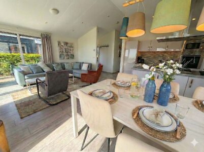 Heller, offener Wohn- und Essbereich mit gedecktem Tisch, moderner Küche, Sofa und großen Fenstern. - Villa Sea Side
