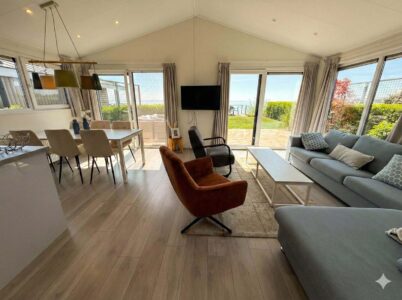 Moderner Wohn- und Essbereich mit großen Fenstern, Sofa und Terrasse mit Blick aufs Meer in der Villa Sea Side.