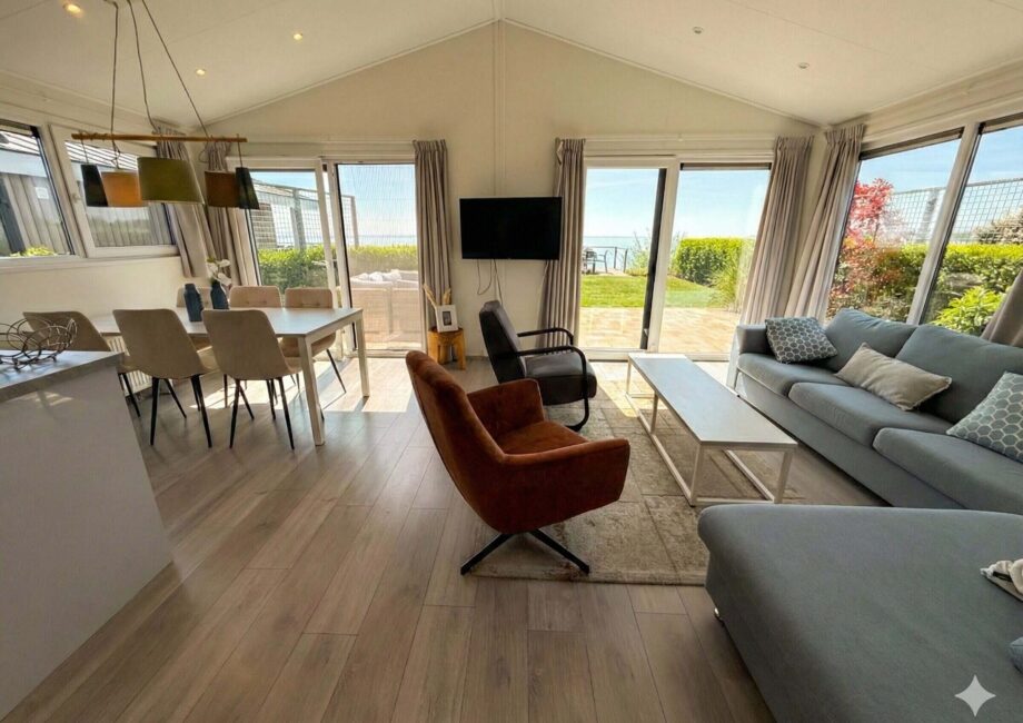 Moderner Wohn- und Essbereich mit großen Fenstern, Sofa und Terrasse mit Blick aufs Meer in der Villa Sea Side.