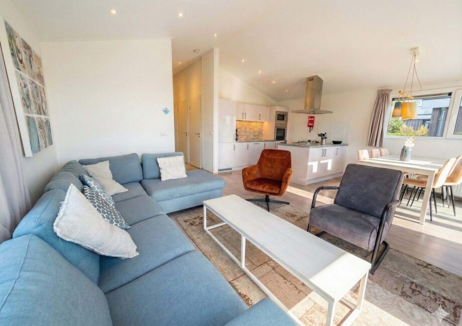 Heller Wohn- und Essbereich mit offener Küche, Sofa, Sesseln und großem Fenster in modernem Ferienhaus. - Villa Sea Side